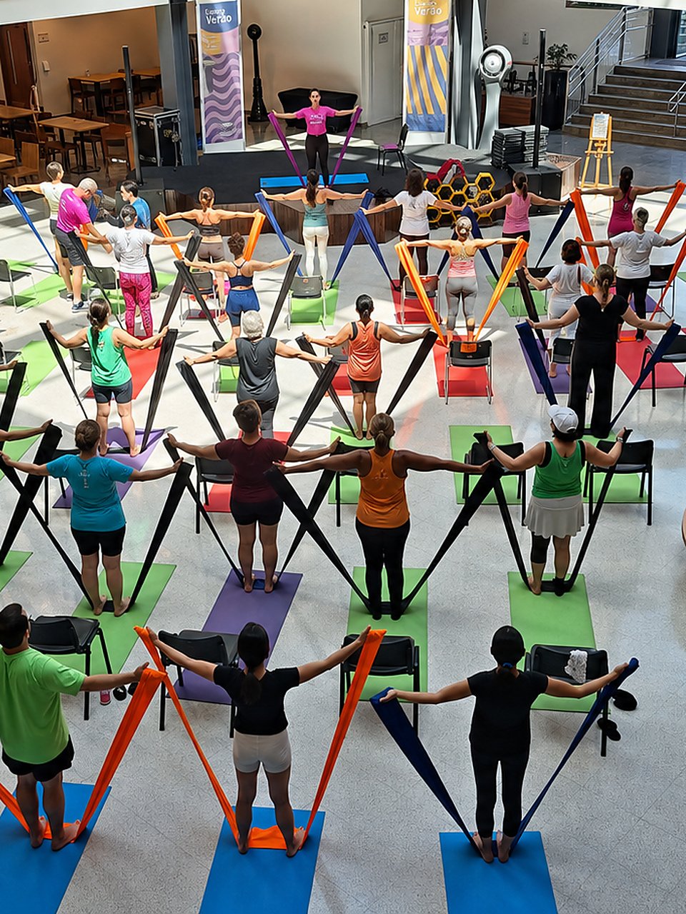 Aula coletiva Infinity Bands com participantes em colchonetes coloridos